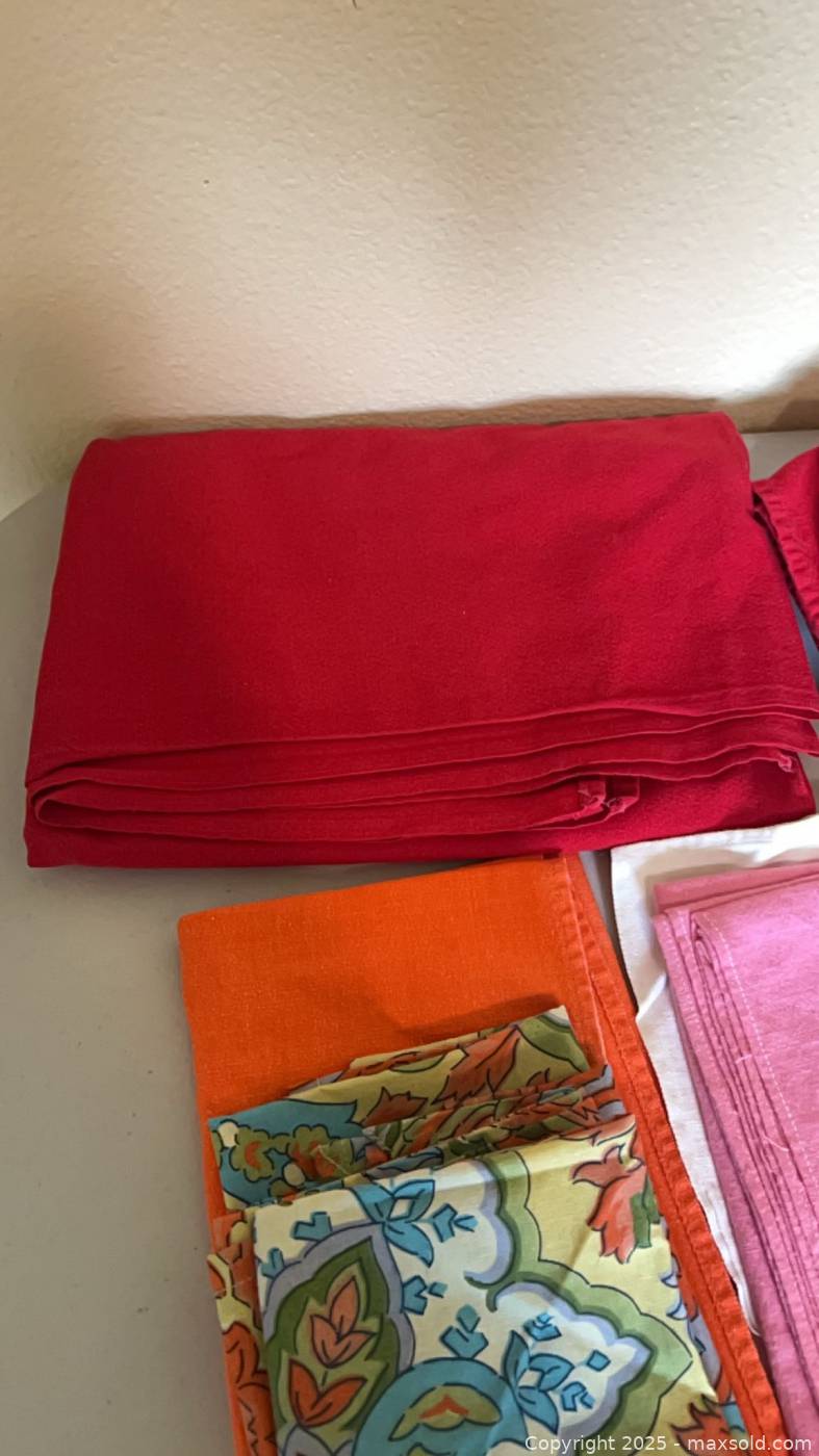 Assorted cloth napkins and red tablecloth | Maxsold