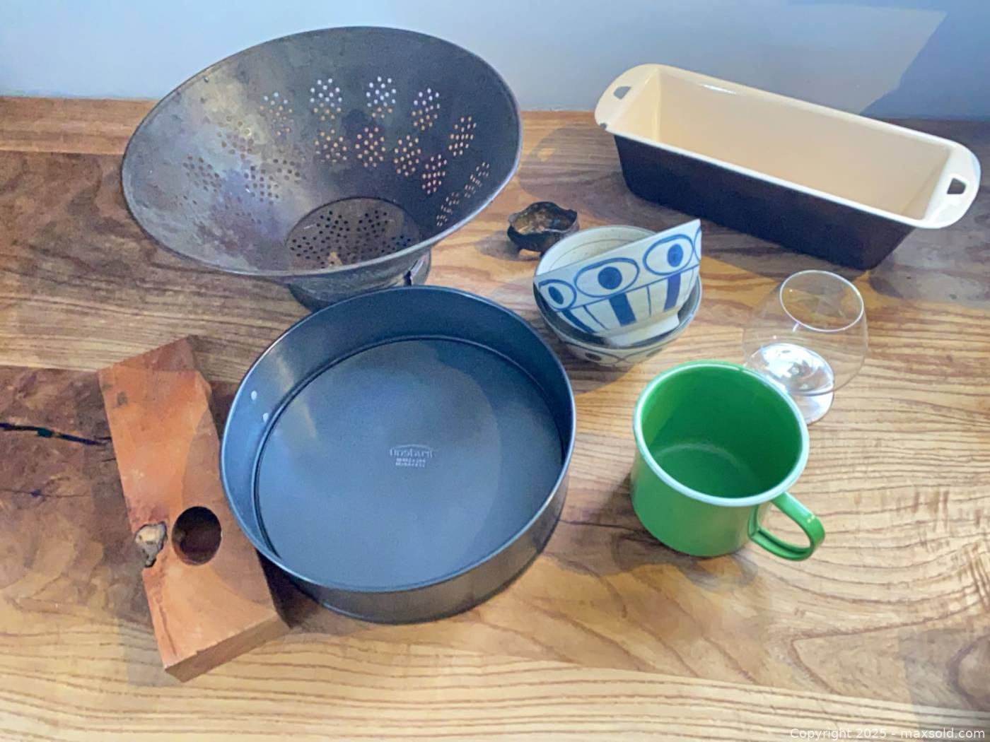 12-piece kitchenware lot: colander, pans, bowls, mug, glass, wine ...