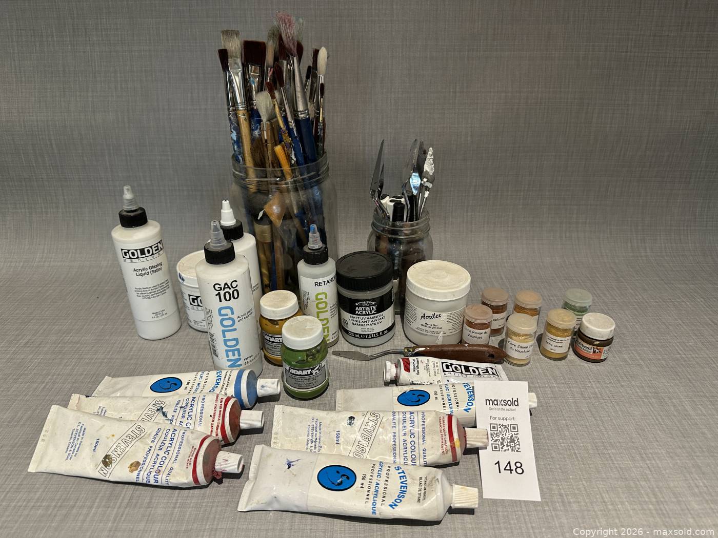 Assorted artist supplies Golden mediums brushes palette knives paint ...